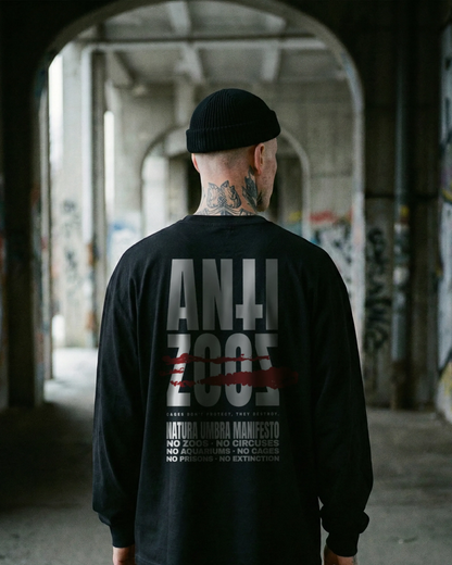 Männliches Model trägt Stanley/Stella Freestyler Longsleeve in Schwarz – "Anti Zoos" Backprint – Relaxed Fit Unisex Shirt aus Bio-Baumwolle.