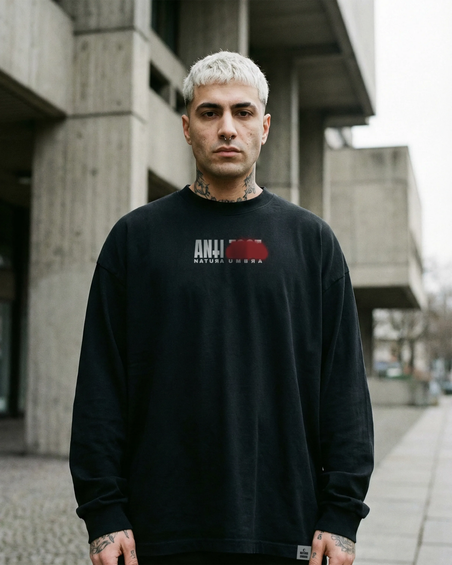 Männliches Model trägt Stanley/Stella Freestyler Longsleeve in Schwarz – kleiner "Anti Zoos" Frontprint – Relaxed Fit Unisex Shirt aus Bio-Baumwolle.