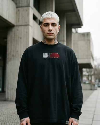 Männliches Model trägt Stanley/Stella Freestyler Longsleeve in Schwarz – kleiner "Anti Zoos" Frontprint – Relaxed Fit Unisex Shirt aus Bio-Baumwolle.