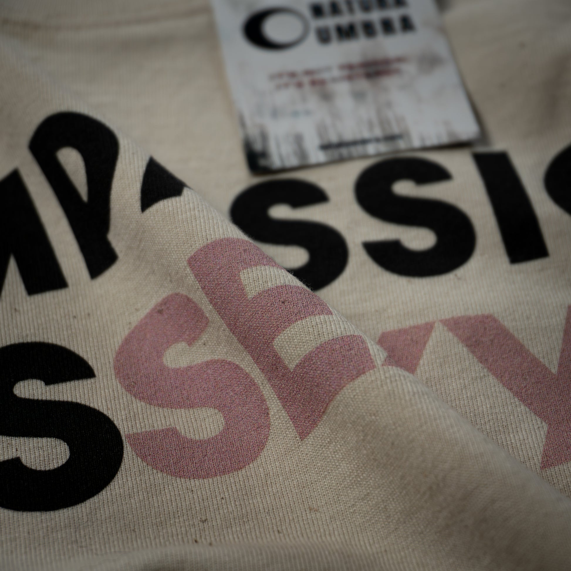 Nachhaltiges Oversized T-Shirt in Natural Raw mit dem Print „Compassion is Sexy“ – Detailansicht des Drucks und der Bio-Baumwollstruktur, Stanley/Stella Freestyler von Natura Umbra.