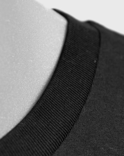 Detailaufnahme des Kragens am Stanley/Stella Rocker Unisex T-Shirt in Schwarz – hochwertiger Rippkragen aus GOTS-zertifizierter Bio-Baumwolle.