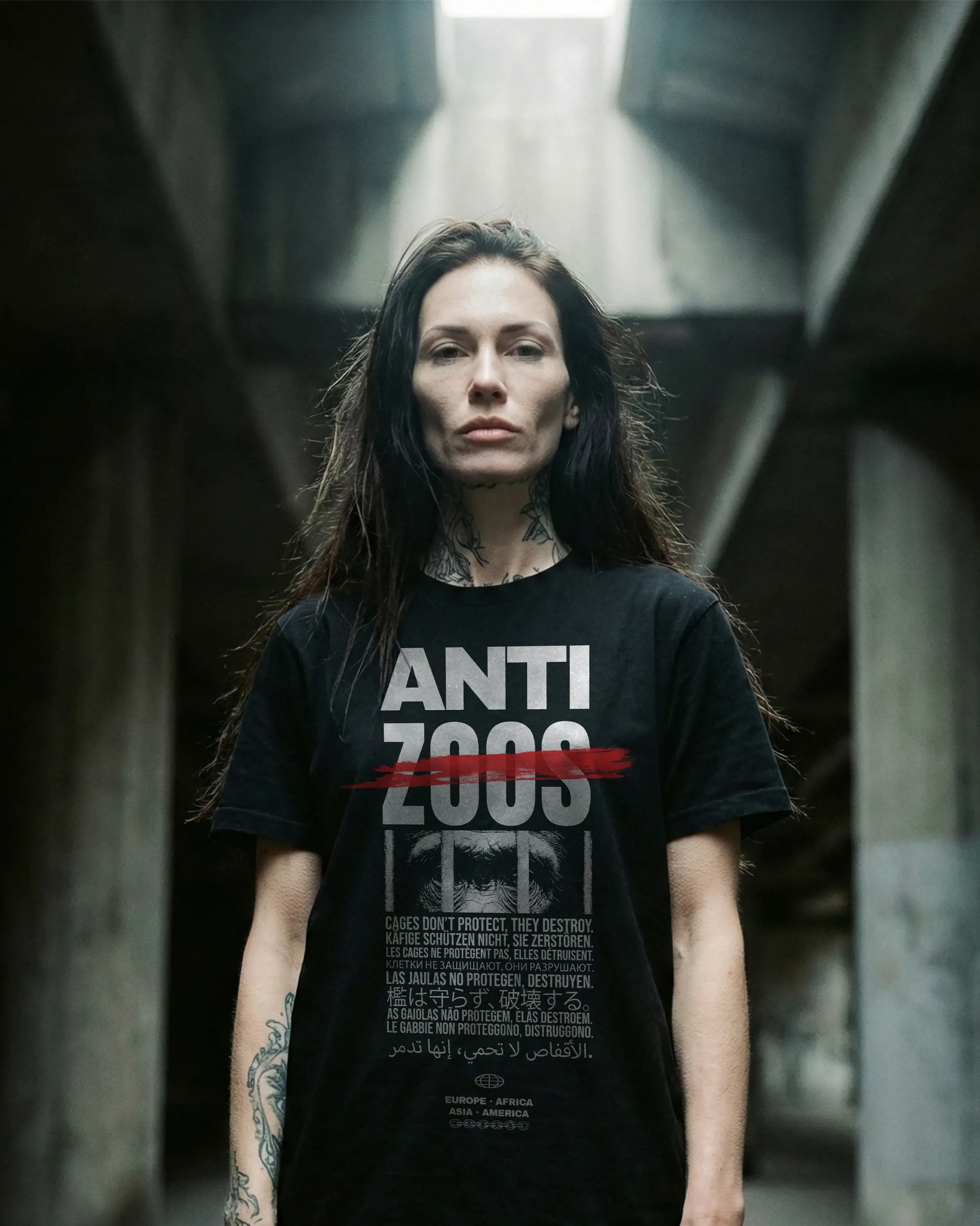 Weibliches Model mit schwarzem Stanley/Stella Rocker T-Shirt – Frontprint „Anti Zoos“, nachhaltig produziert aus Bio-Baumwolle, Label Natura Umbra.