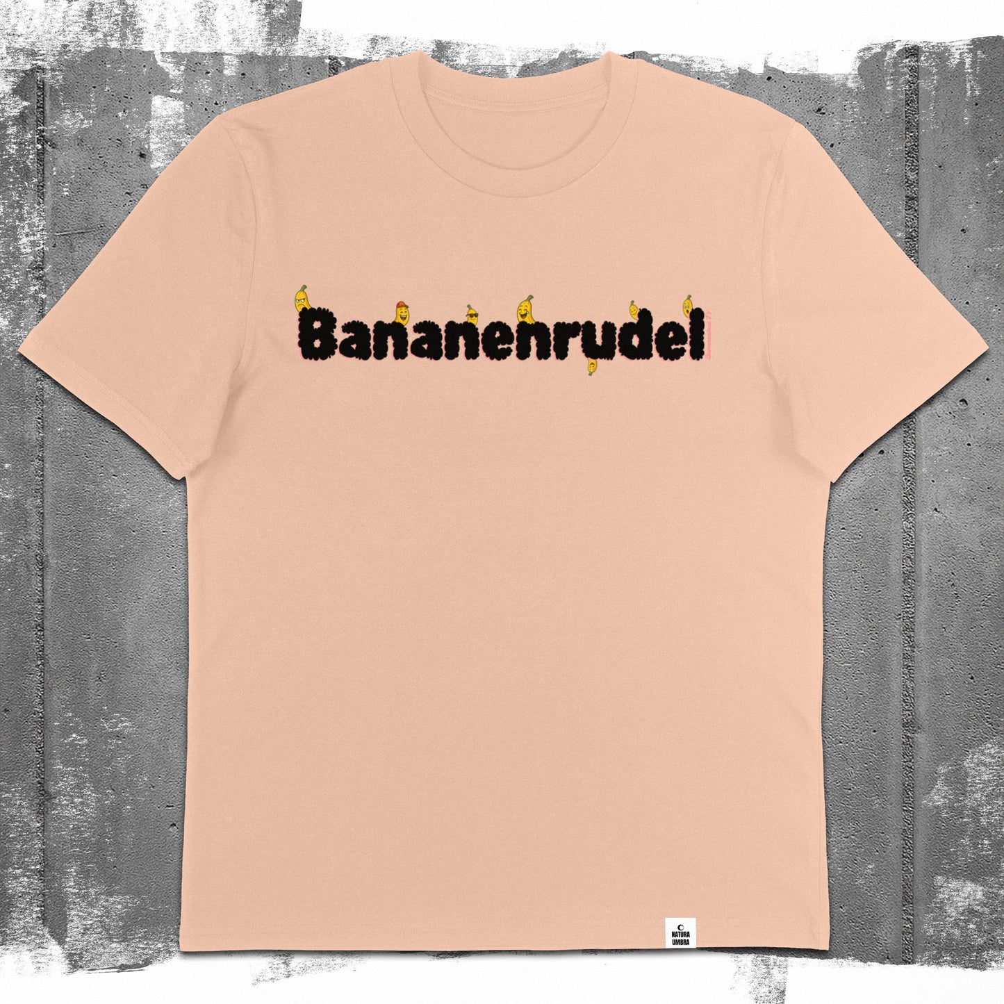 Nachhaltiges Unisex T-Shirt von Natura Umbra in Fraiche Peche mit Frontprint „Bananenrudel“ – Flatlay des Stanley/Stella Creator 2.0.