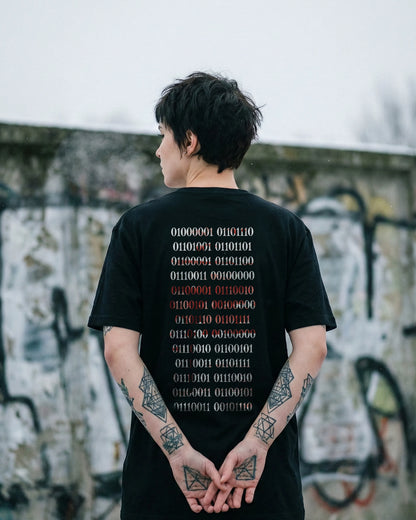 Nachhaltiges Unisex T-Shirt in Schwarz von Natura Umbra – Stanley/Stella Creator 2.0 mit digitalem Backprint „Binärcode“, getragen von einem Model.