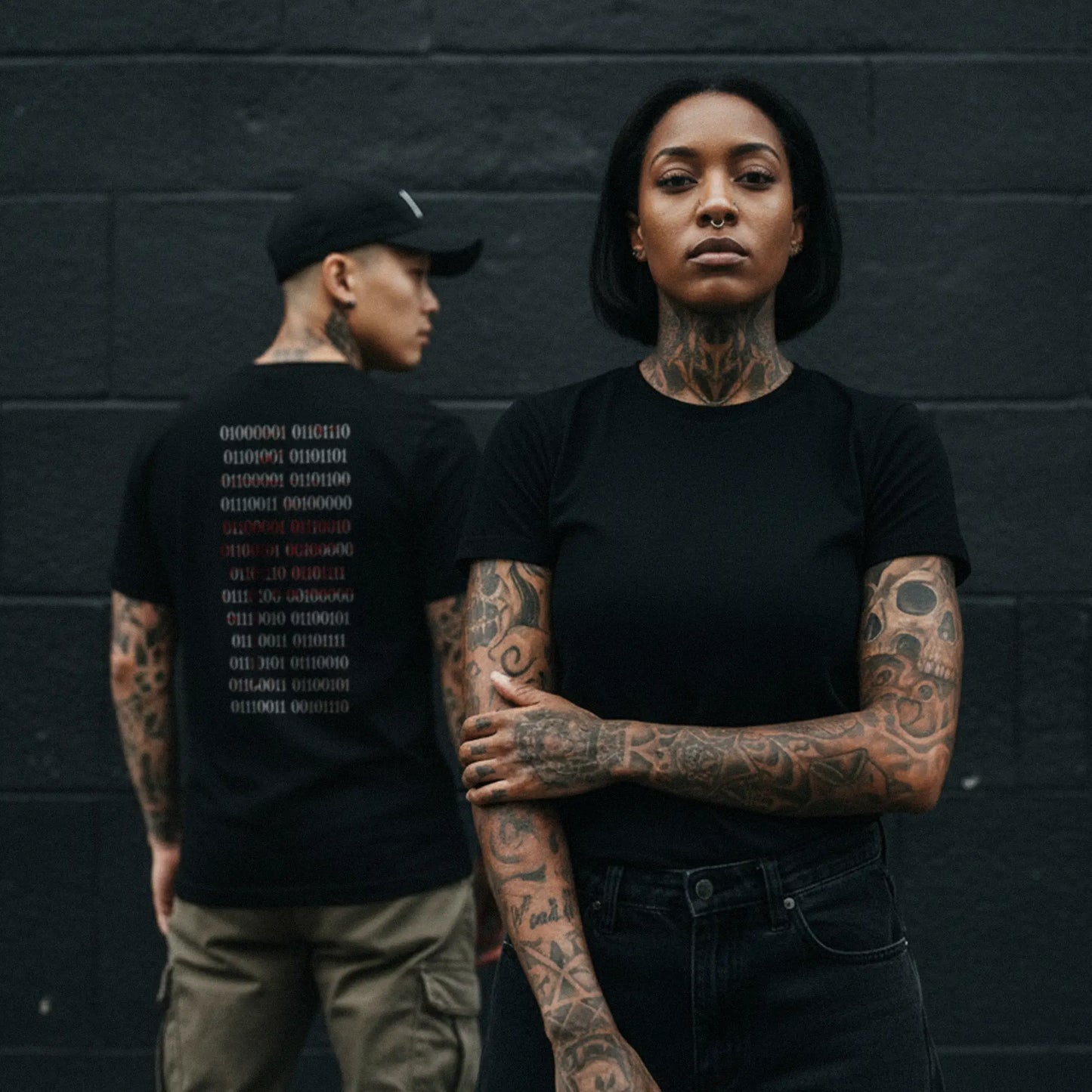 Nachhaltiges Unisex T-Shirt in Schwarz von Natura Umbra – Stanley/Stella Creator 2.0 mit digitalem Backprint „Binärcode“, getragen von zwei unterschiedlichen Models.