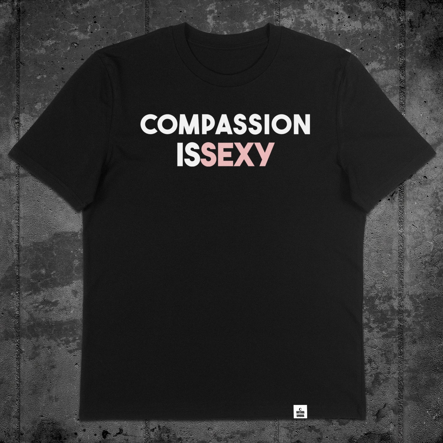 Nachhaltiges Unisex T-Shirt von Natura Umbra in Schwarz mit Frontprint „Compassion is sexy“ – Flatlay des Stanley/Stella Creator 2.0.