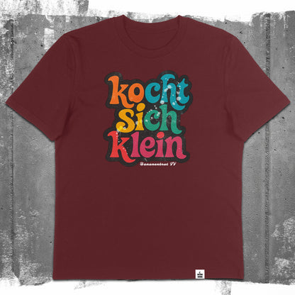 Flatlay des Unisex T-Shirts „Kocht sich klein“ in der Farbe Burgundy – Stanley/Stella Creator 2.0 von Natura Umbra mit Frontprint.