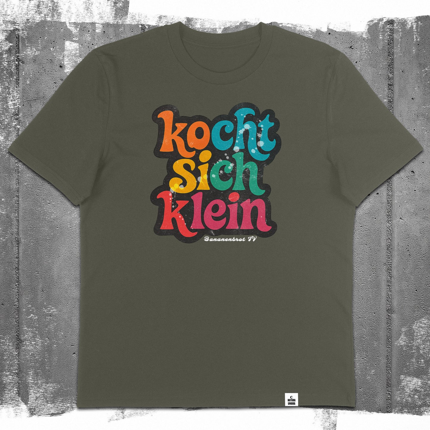 Flatlay des Unisex T-Shirts „Kocht sich klein“ in der Farbe Khaki – Stanley/Stella Creator 2.0 von Natura Umbra mit Frontprint.